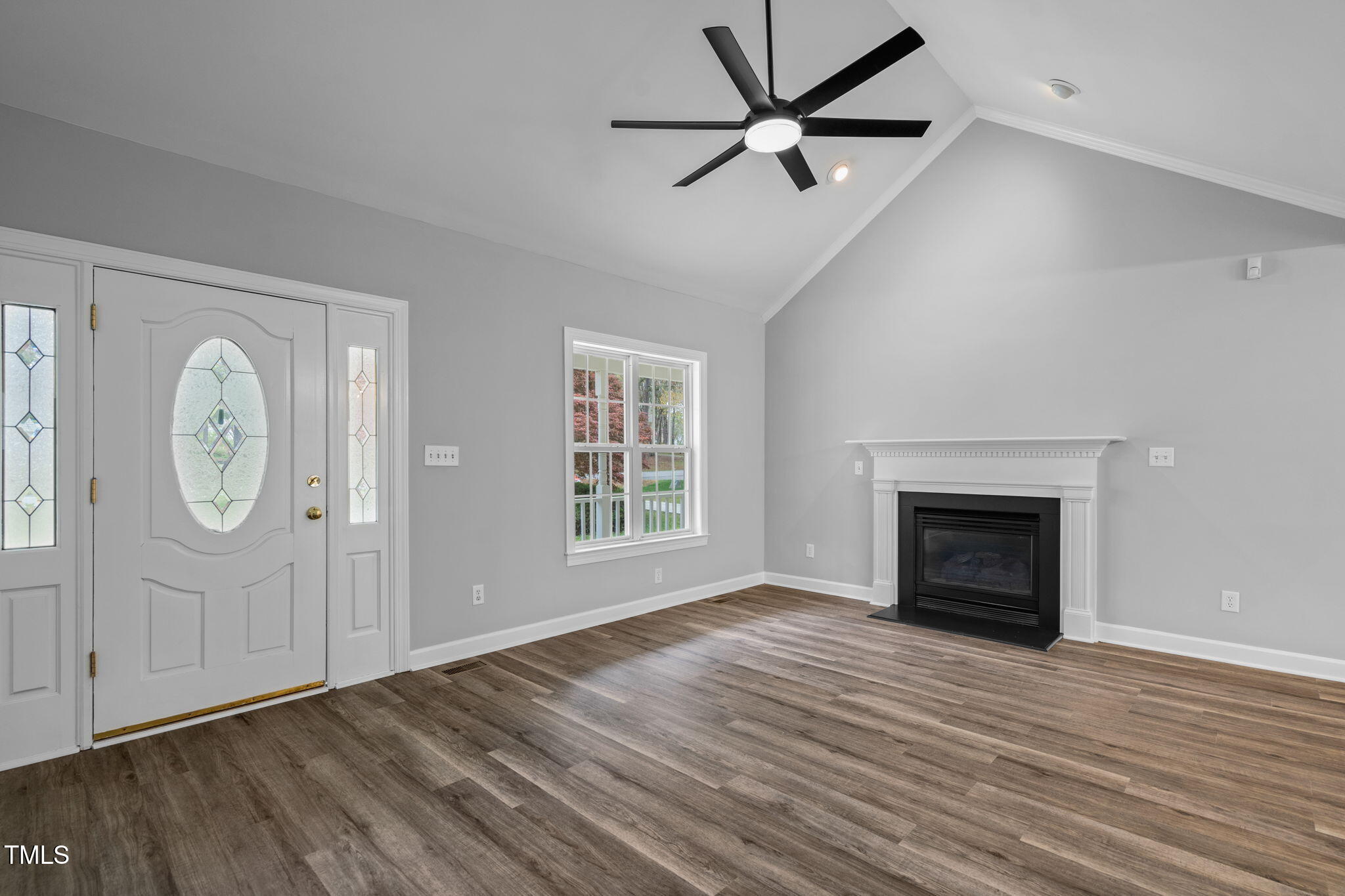 340 Castleberry Road Clayton, NC 27527 - Photo 9 of 31 an empty room with wooden floor a ceiling fan and windows