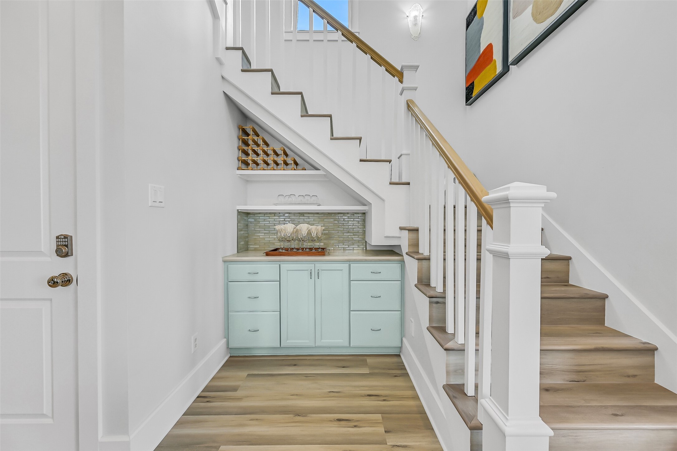 817 Positano Road Galveston, TX 77550 - Photo 21 of 50 Custom built-ins beneath the staircase add both charm and functionality. The thoughtfully designed storage and serving area enhance everyday convenience and entertaining.