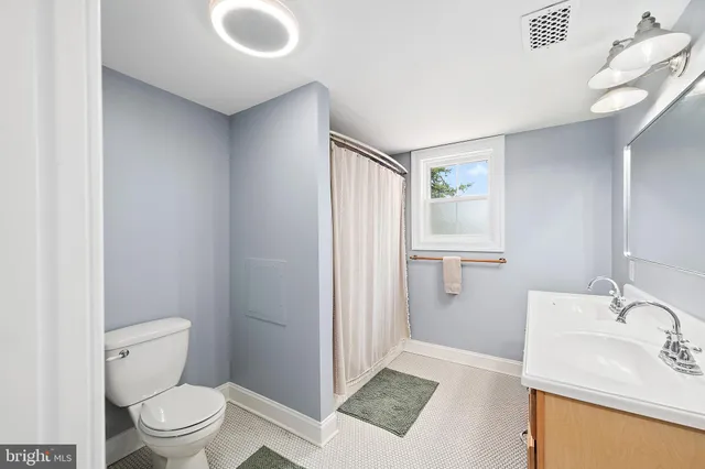 a backyard of a house with plants and large tree