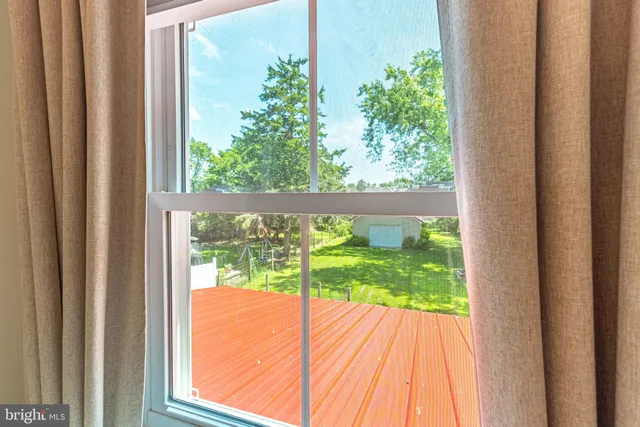a view of a house with a yard potted plants and a large tree