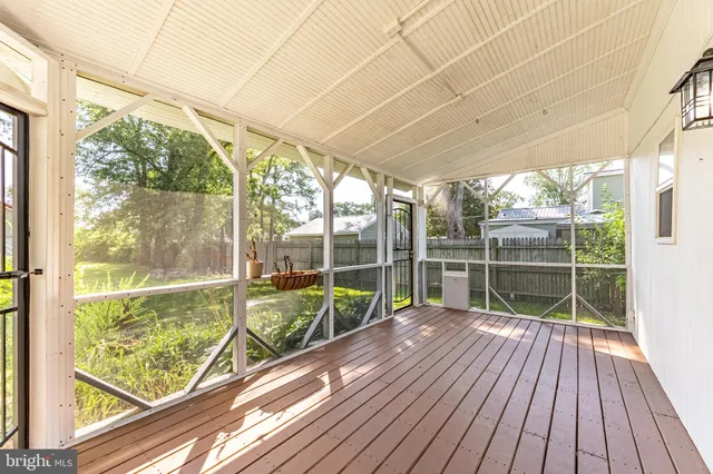 a sign of golf club on a wall under a large tree