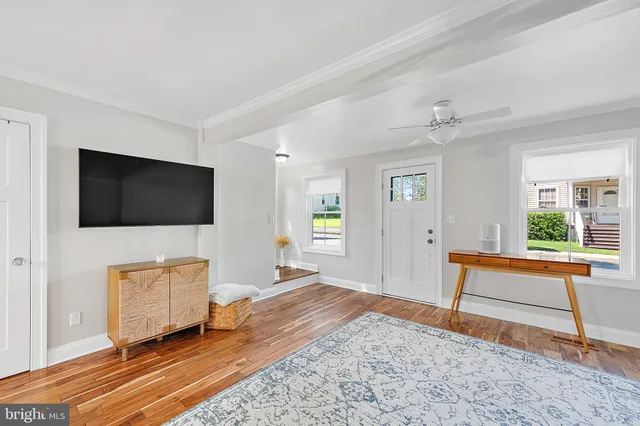 a kitchen with stainless steel appliances a dining table chairs stove and white cabinets