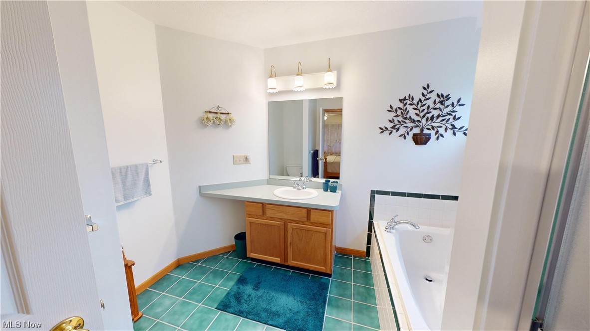 12431 Carter Road Painesville, OH 44077 - Photo 20 of 33 Bathroom featuring a bath, tile floors, and vanity