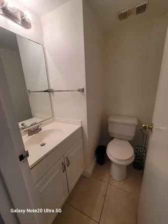 a kitchen with a stove a refrigerator and white cabinets