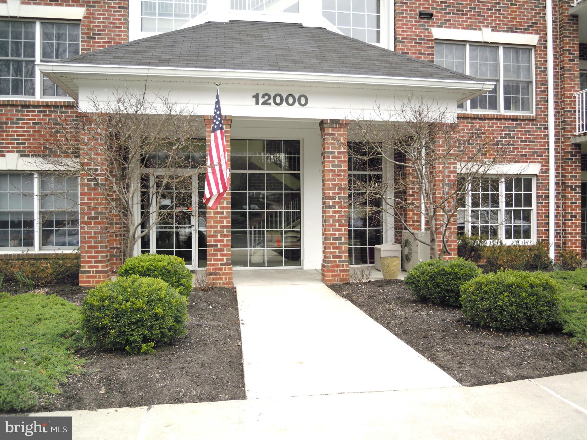 12000 Tralee Road, Unit 302 Lutherville-Timonium, MD 21093 - Photo 1 of 28 a front view of a building with a garden