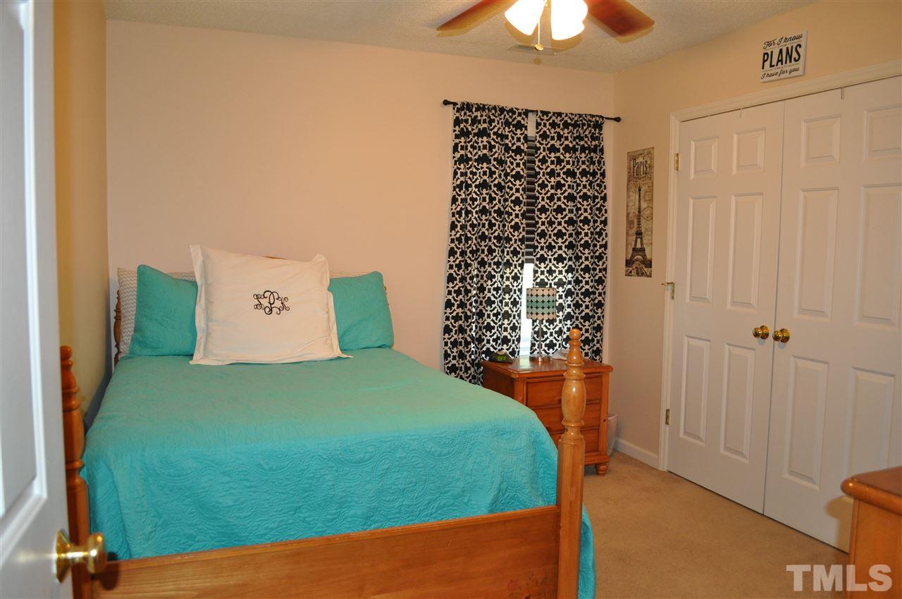 4904 Mocha Lane Raleigh, NC 27616 - Photo 10 of 15 a bedroom with a bed and a chandelier