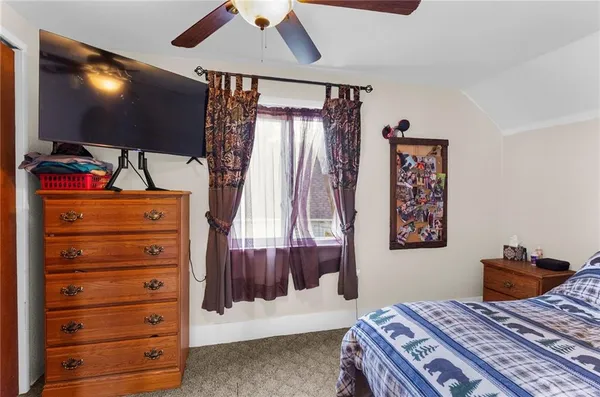 a bedroom with a bed and a flat tv screen