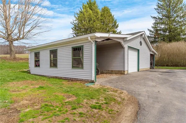 a backyard of a house with large trees and brick wall