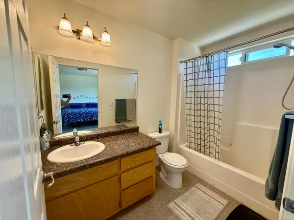 a bathroom with a granite countertop sink toilet and shower