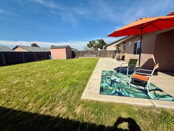 a backyard of a house with table and chairs
