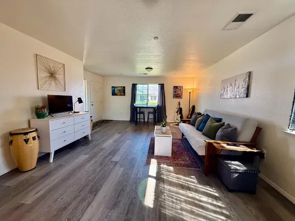 a living room with furniture and a wooden floor