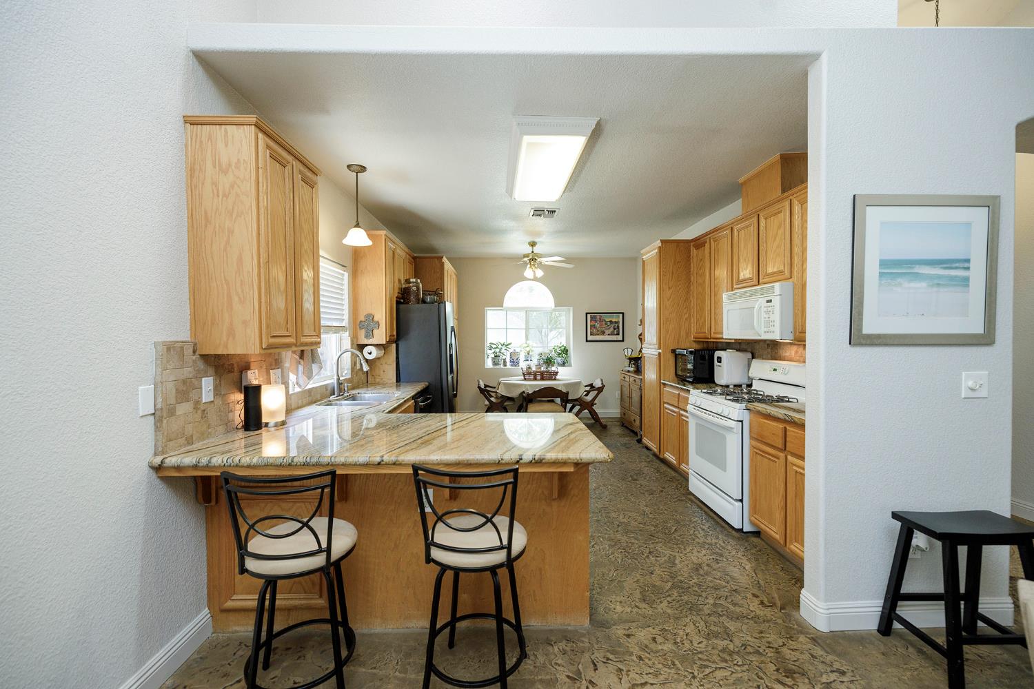 3731 Incline Way Riverbank, CA 95367 - Photo 14 of 49 a kitchen with stainless steel appliances kitchen island granite countertop a stove a sink and a refrigerator with wooden floor