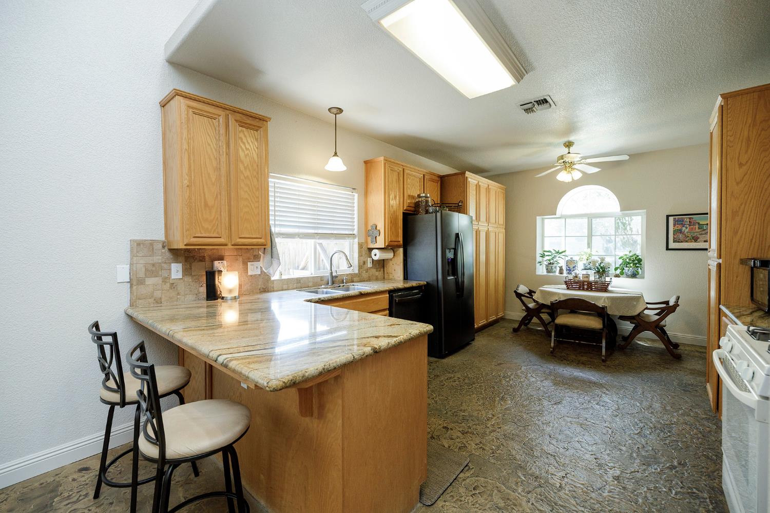3731 Incline Way Riverbank, CA 95367 - Photo 15 of 49 a kitchen with a table chairs and refrigerator