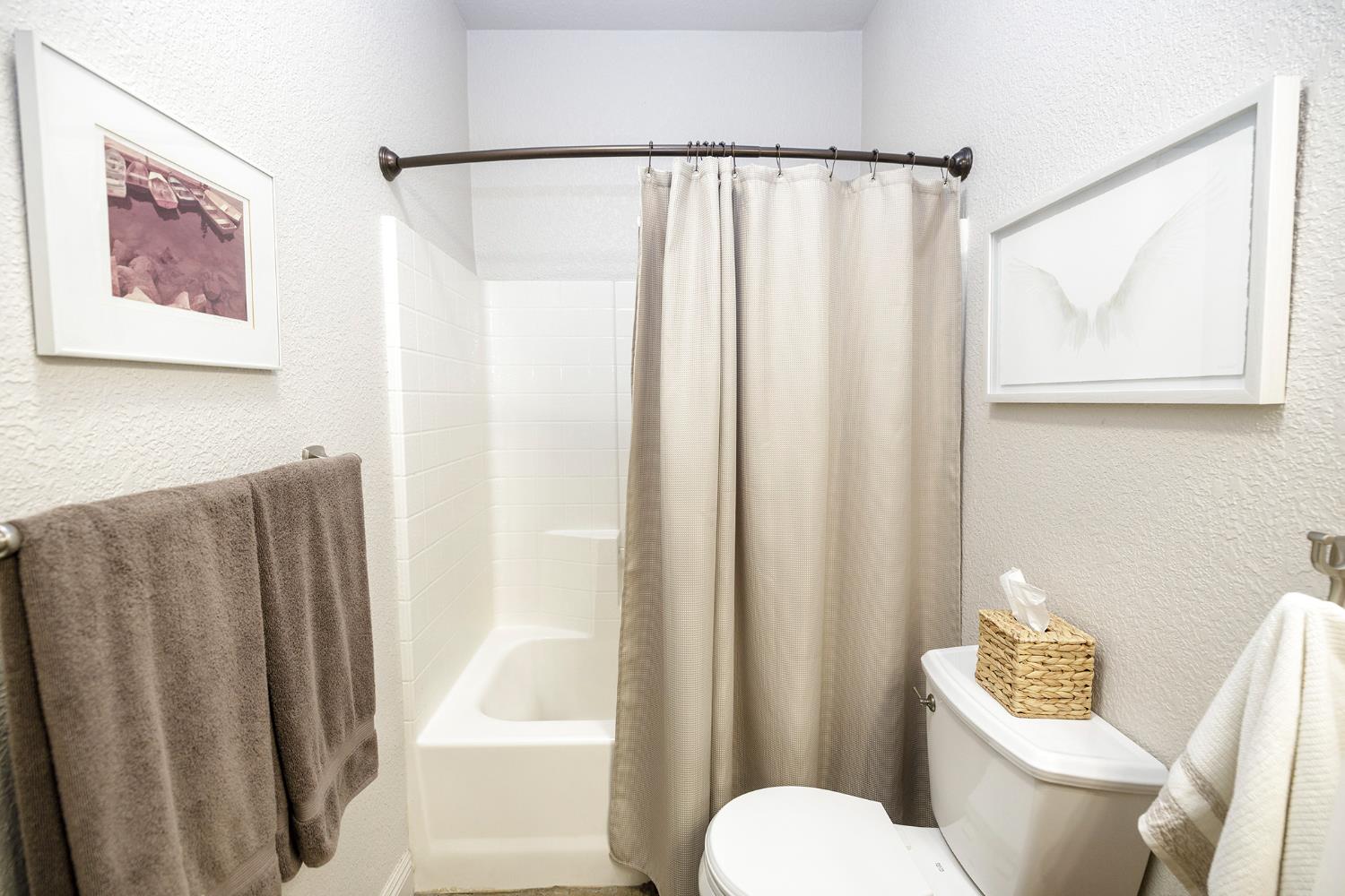 3731 Incline Way Riverbank, CA 95367 - Photo 28 of 49 a white toilet sitting next to a shower curtain