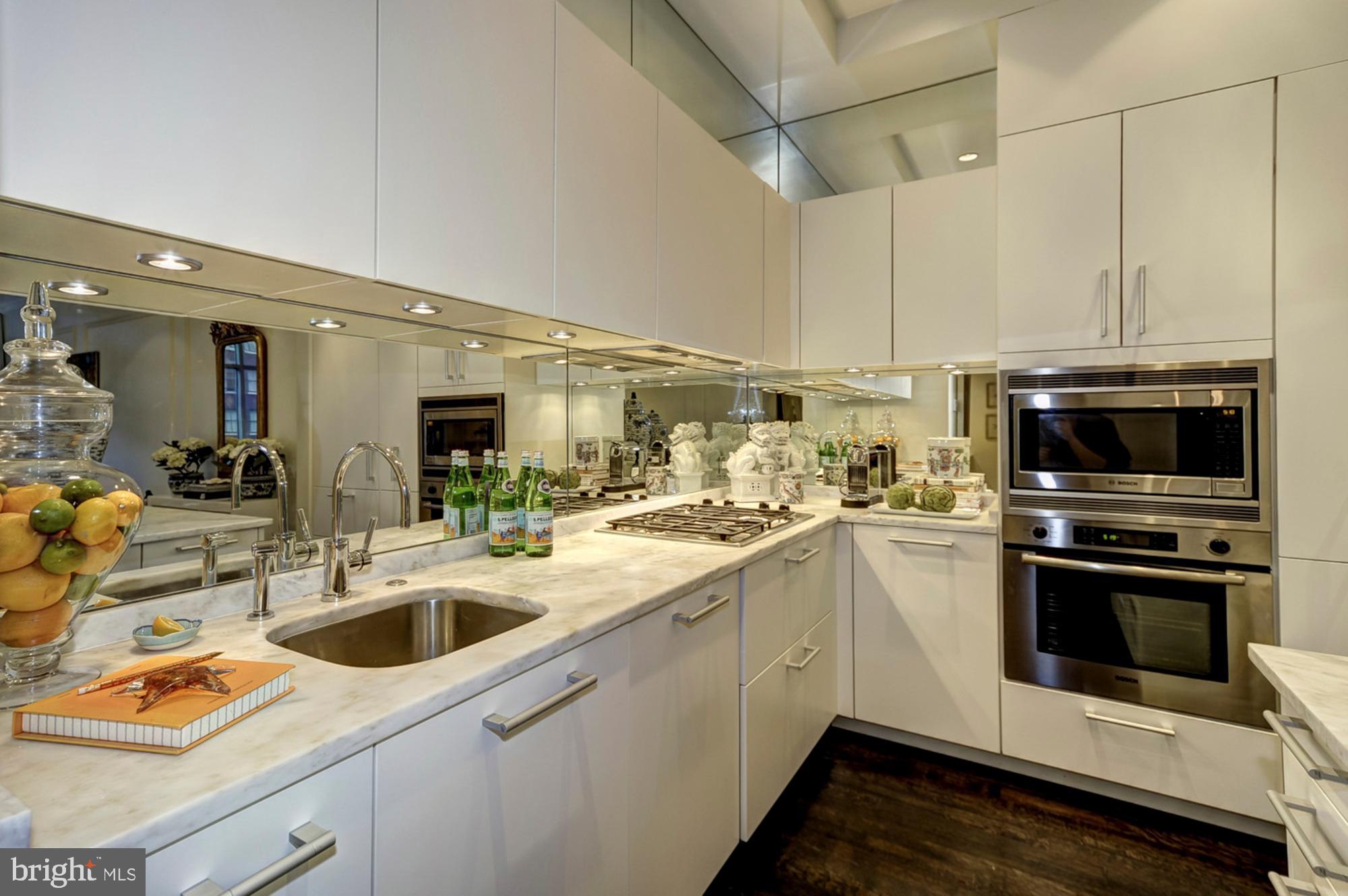 1177 22nd Street Northwest, Unit 3H Washington, DC 20037 - Photo 5 of 17 a kitchen with stainless steel appliances granite countertop a sink and white cabinets