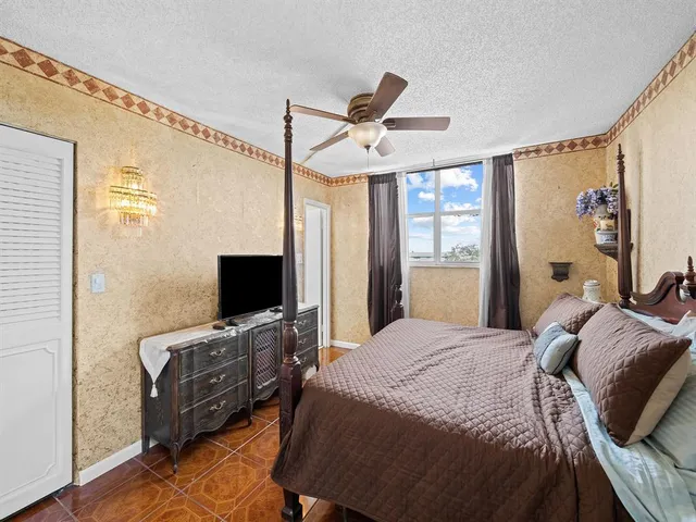 a bedroom with a bed flat screen tv and a window