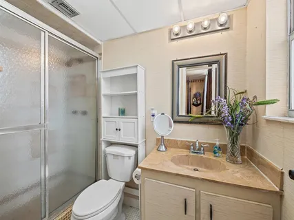 a bathroom with a granite countertop sink a toilet and shower