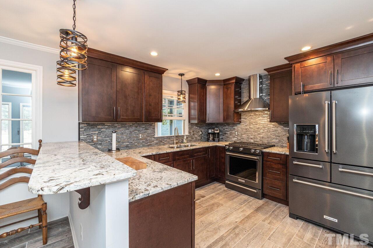 4808 Waybridge Court Raleigh, NC 27606 - Photo 11 of 29 a kitchen with stainless steel appliances granite countertop a sink stove and refrigerator