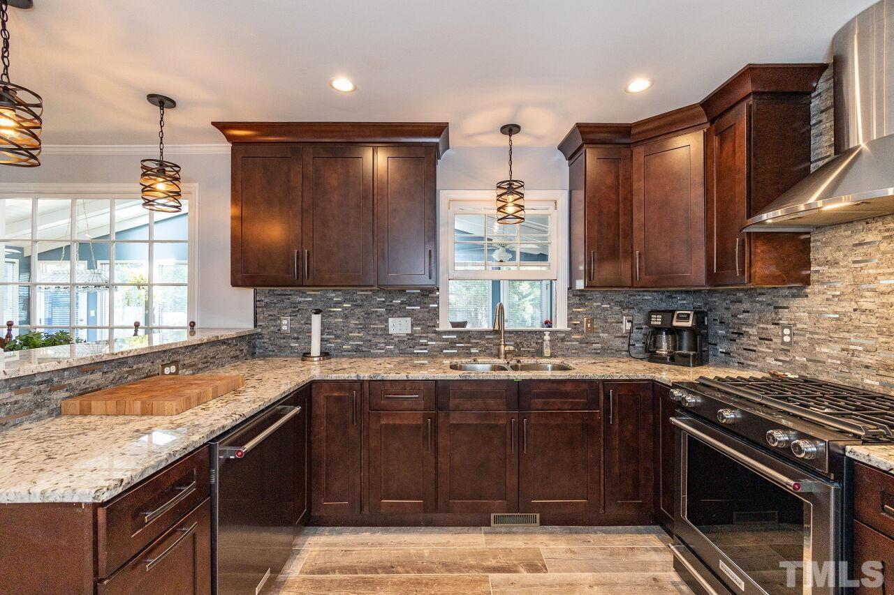 4808 Waybridge Court Raleigh, NC 27606 - Photo 12 of 29 a kitchen with stainless steel appliances granite countertop a sink stove and microwave