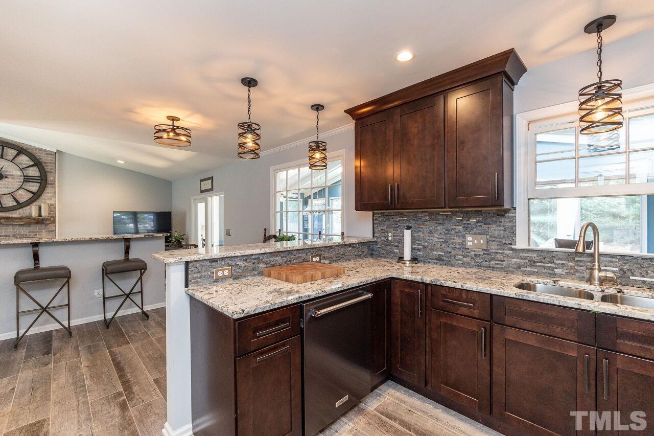 4808 Waybridge Court Raleigh, NC 27606 - Photo 13 of 29 a kitchen with a sink counter top space and living room