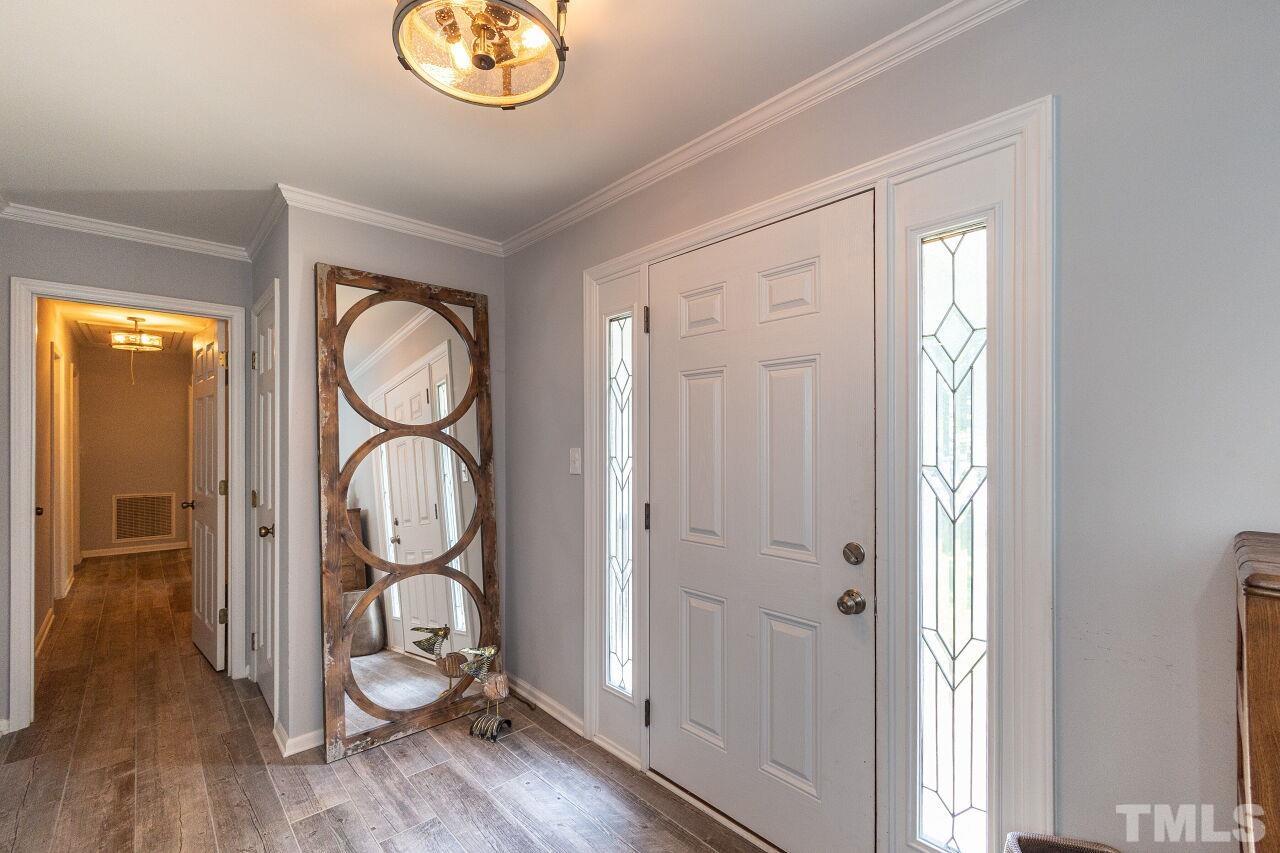 4808 Waybridge Court Raleigh, NC 27606 - Photo 4 of 29 a view of a hallway with wooden floor and cabinets