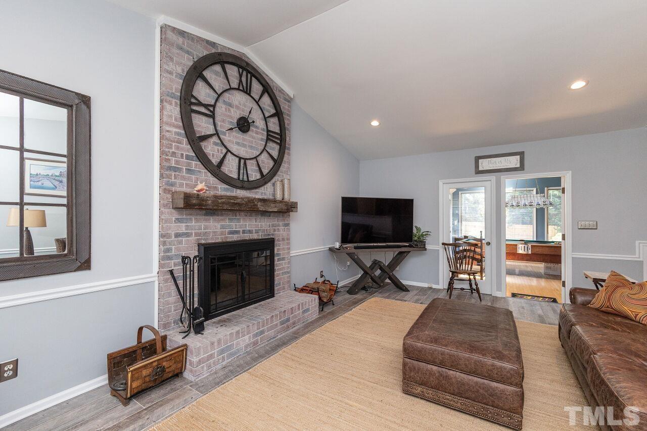 4808 Waybridge Court Raleigh, NC 27606 - Photo 6 of 29 a living room with furniture a fireplace and a flat screen tv