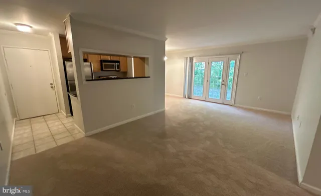 a view of a big room with wooden floor and windows