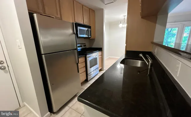 a view of a refrigerator in kitchen and windows