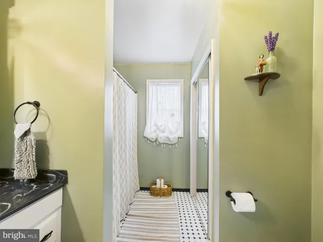 a backyard of a house with a bench and trees