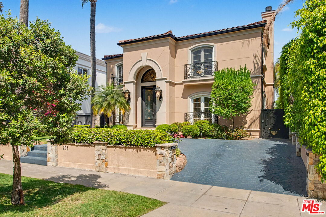 204 Foothill Road Beverly Hills, CA 90210 - Photo 3 of 38 a front view of a house with a yard and trees