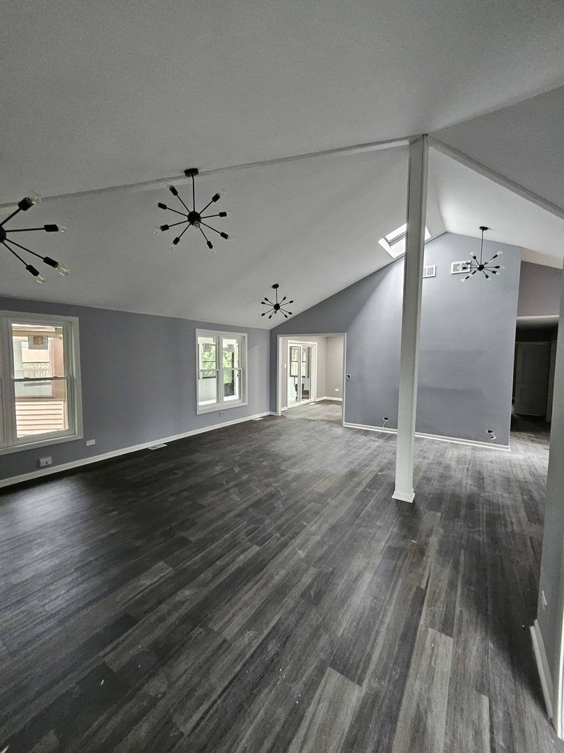17612 Wright Street Lansing, IL 60438 - Photo 18 of 40 an empty room with wooden floor chandelier and windows