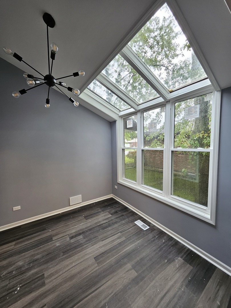 17612 Wright Street Lansing, IL 60438 - Photo 19 of 40 a view of an empty room with wooden floor and a window