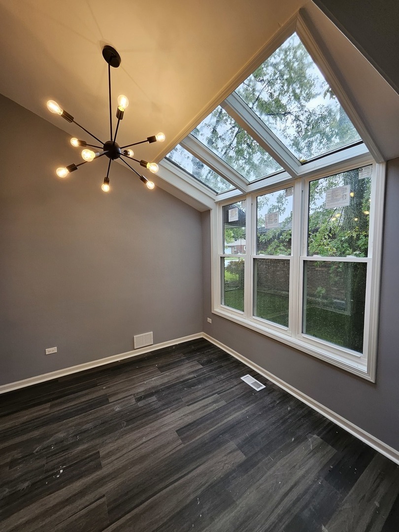 17612 Wright Street Lansing, IL 60438 - Photo 21 of 40 a view of an empty room with wooden floor and a window