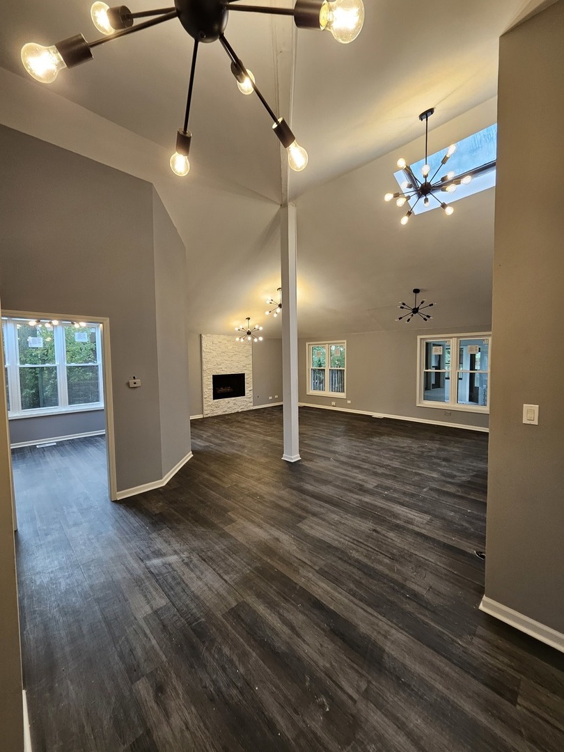 17612 Wright Street Lansing, IL 60438 - Photo 28 of 40 a view of a room with wooden floor a ceiling fan and windows