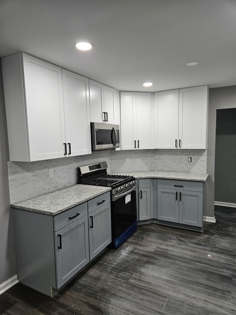 17612 Wright Street Lansing, IL 60438 - Photo 10 of 40 a kitchen with stainless steel appliances granite countertop a sink a stove a refrigerator and cabinets
