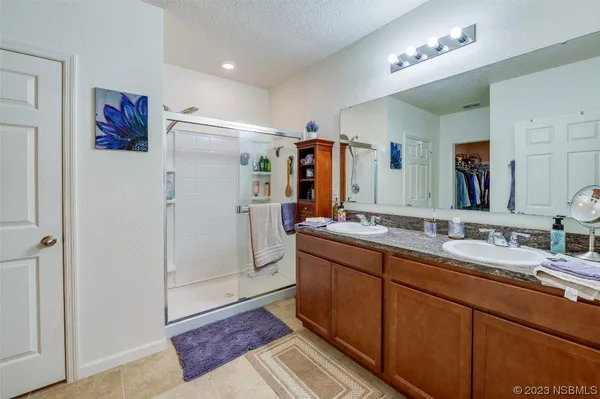 a bathroom with double vanity and a mirror