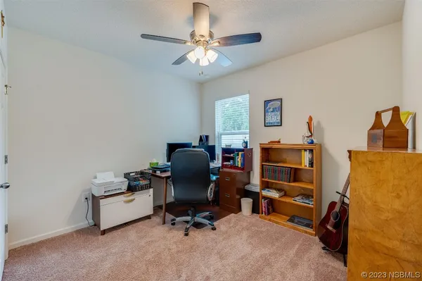 a bedroom with furniture and a chandelier fan
