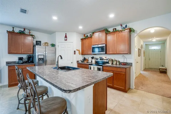 a kitchen with granite countertop stainless steel appliances a sink and a refrigerator