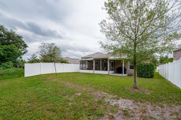 a view of a house with a yard and trees