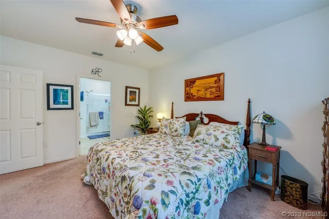 a bed sitting in a bedroom and a flat screen tv