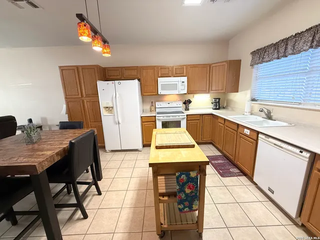 a kitchen with a sink a stove a refrigerator and cabinetry