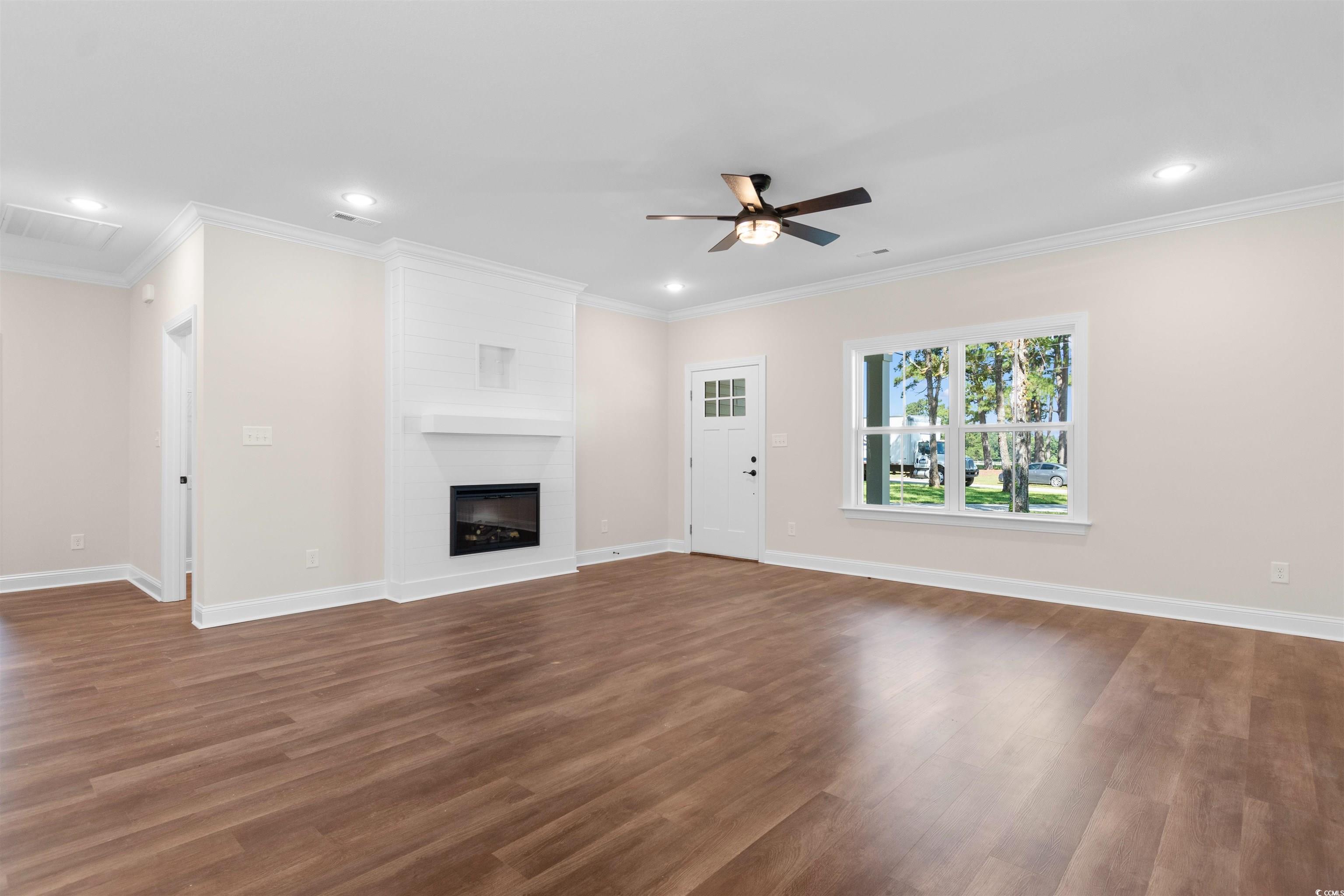 146 Temple Drive Aynor, SC 29511 - Photo 10 of 40 Unfurnished living room with ornamental molding, dark wood finished floors, a fireplace, recessed lighting, and a ceiling fan