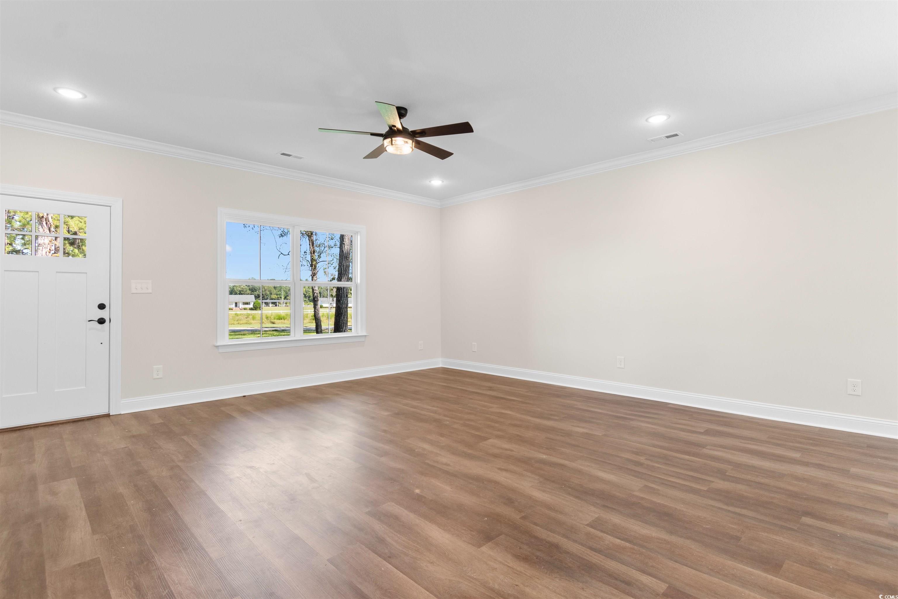 146 Temple Drive Aynor, SC 29511 - Photo 11 of 40 Unfurnished living room featuring ornamental molding, dark wood finished floors, a ceiling fan, and recessed lighting