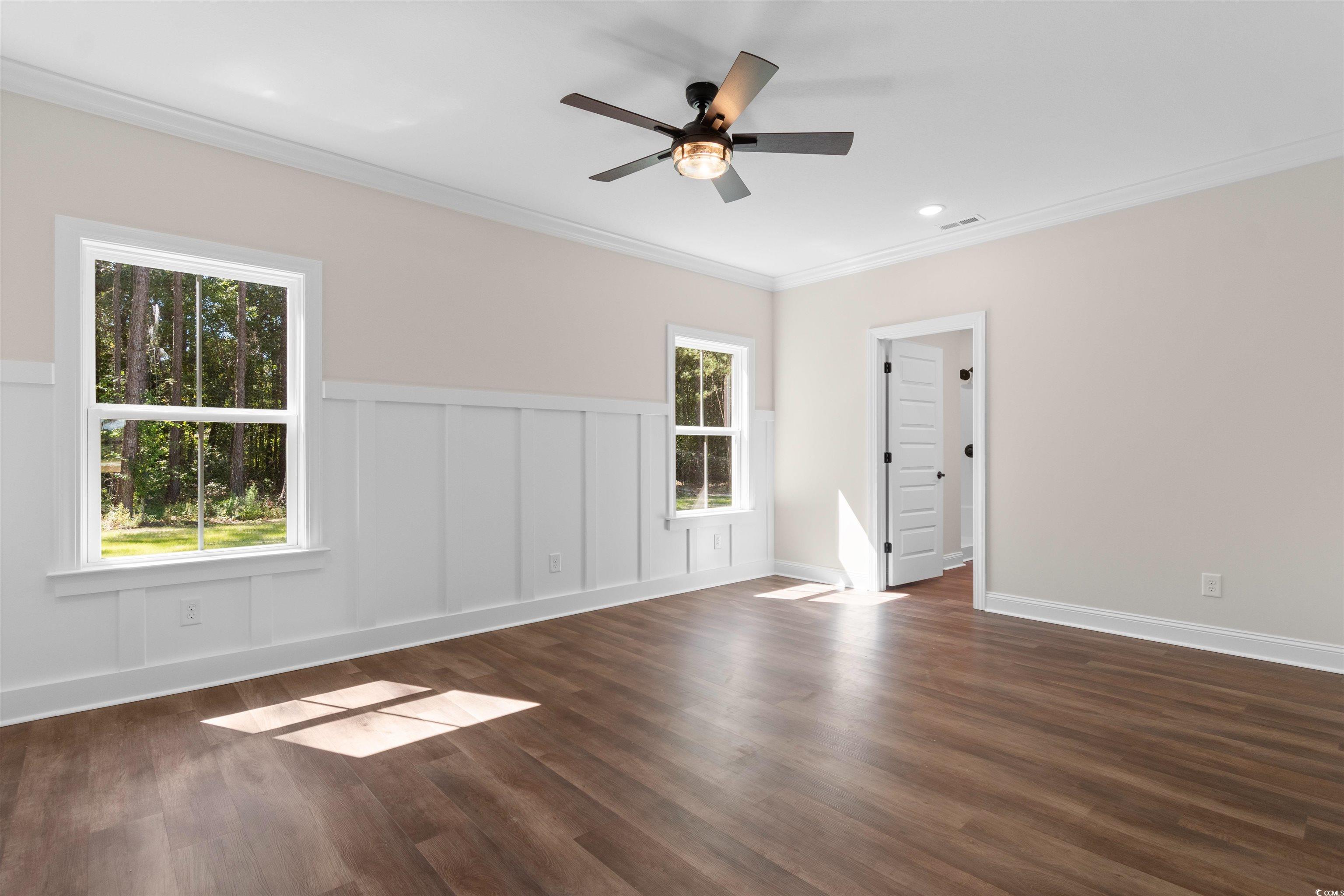 146 Temple Drive Aynor, SC 29511 - Photo 12 of 40 Spare room featuring ornamental molding, a decorative wall, dark wood finished floors, a ceiling fan, and a wainscoted wall
