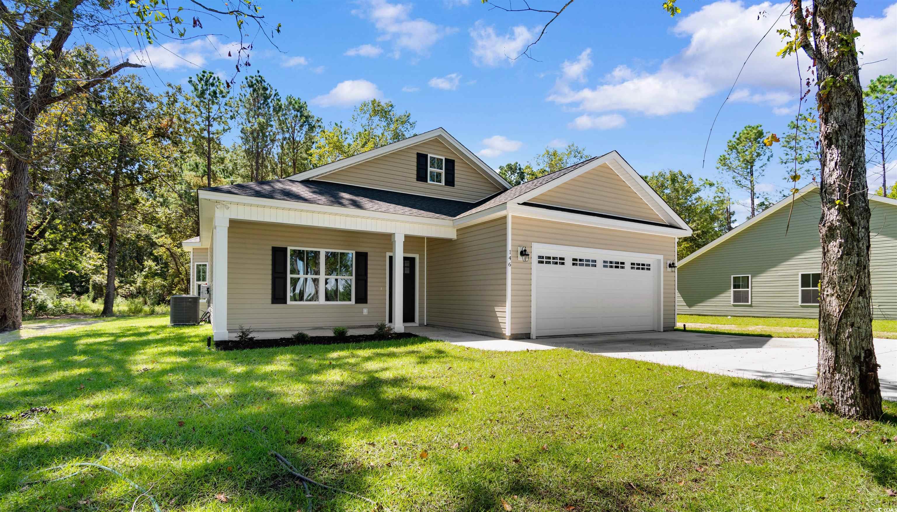 146 Temple Drive Aynor, SC 29511 - Photo 29 of 40 View of front of house featuring a front yard, a shingled roof, driveway, a garage, and a porch