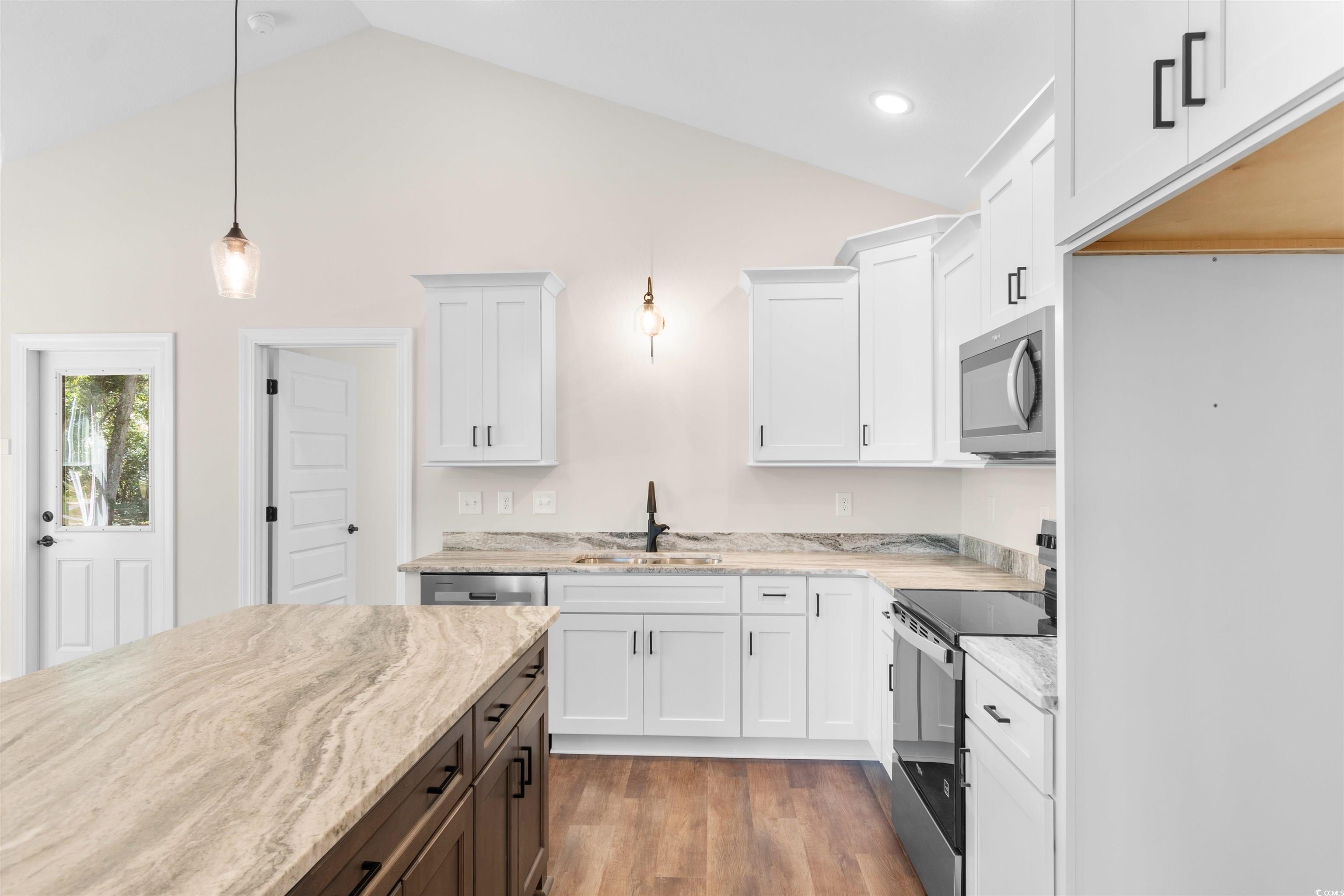 146 Temple Drive Aynor, SC 29511 - Photo 5 of 40 Kitchen featuring appliances with stainless steel finishes, white cabinets, decorative light fixtures, light wood-type flooring, and light stone countertops
