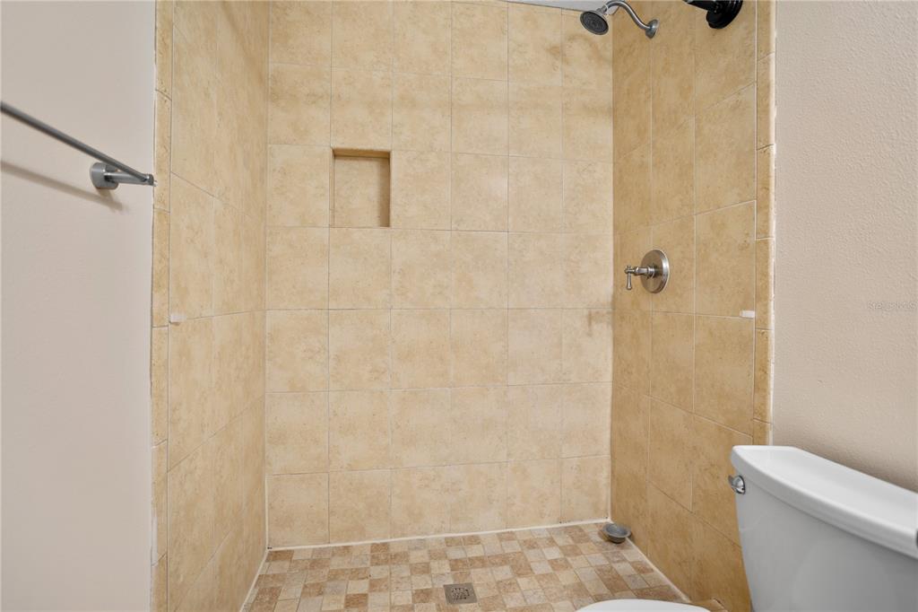 7337 Cedar Creek Court, Unit 75 Winter Park, FL 32792 - Photo 16 of 26 a bathroom with a granite countertop shower and a toilet