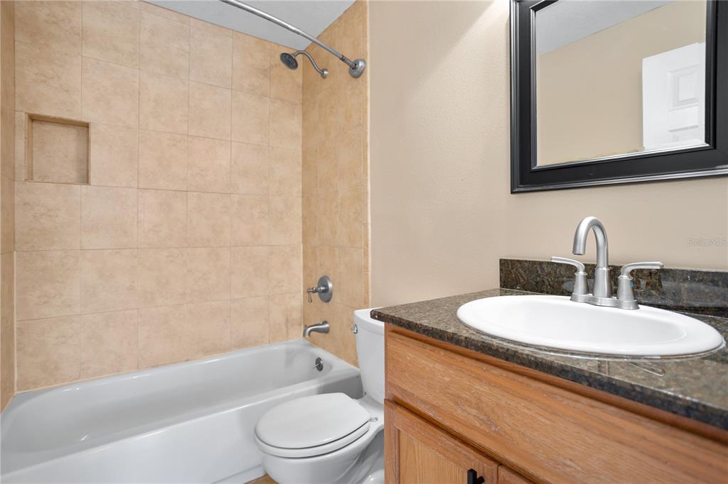 7337 Cedar Creek Court, Unit 75 Winter Park, FL 32792 - Photo 19 of 26 a bathroom with a granite countertop sink toilet mirror and shower
