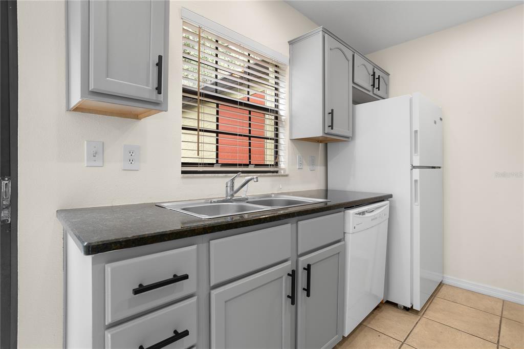 7337 Cedar Creek Court, Unit 75 Winter Park, FL 32792 - Photo 4 of 26 a kitchen with stainless steel appliances granite countertop a sink and a cabinets