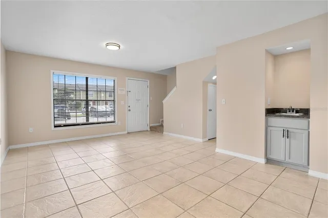 an empty room with kitchen and window